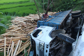 Xe tải chở gỗ lật xuống suối, tài xế thoát chết trong gang tấc