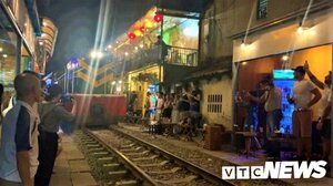 Video: Du khách liều mình uống cà phê, chụp ảnh ngay sát đường ray tàu ở Hà Nội