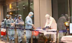 Ảnh: 30 công dân Việt Nam trở về từ Vũ Hán mặc quần áo bảo hộ, đeo khẩu trang kín mít khi về nước