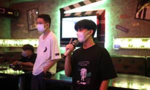 Ảnh: Người TP.HCM vừa đeo khẩu trang vừa hát khi quán karaoke mở lại