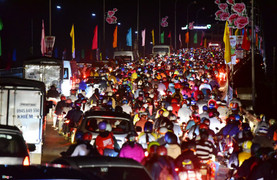 Dòng người xe từ miền Tây ùn ùn đổ về TP.HCM trong đêm, mẹ phải bế con nằm nghỉ lại ven đường