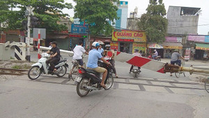 Tàu đang ầm ầm lao tới, dân coi thường mạng sống vẫn cố lách barie băng qua đường ray