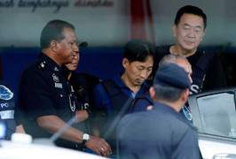 Nghi phạm Triều Tiên mặc áo chống đạn rời khỏi đồn cảnh sát sau khi được thả