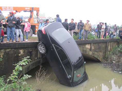 Camry lao xuống kênh, dựng đứng bên thành cầu