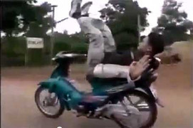 Nam thanh niên nằm ngửa điều khiển xe máy