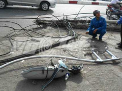 Xe tải kéo trụ điện đổ vật giữa phố