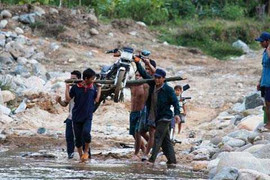 Cảnh khiêng xe qua sông giữa dòng nước xiết