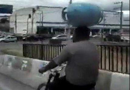 Đi xe đạp, vận chuyển bình gas bằng đầu trên đường phố