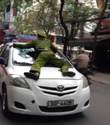 Taxi hất công an lên nắp capo chạy dọc phố giữa Hà Nội