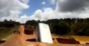 Kinh hoàng xe buýt sụt hố bị lũ cuốn phăng