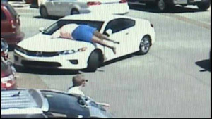 Clip: Một phụ nữ nằm trên nắp capo ngăn cản tên trộm xe