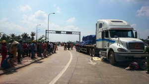 Bé gái gào khóc cầu cứu nhìn mẹ nằm bất động dưới gầm container