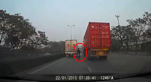 Video: Xe máy cảm tử ‘len’ giữa xe tải và container