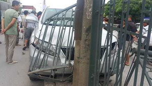 Xe Lexus bay lên dải phân cách, ủi tung hàng rào sắt