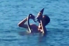 Clip: Kỳ lạ người đàn ông thảnh thơi uống bia, tắm biển cùng… rắn