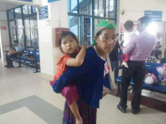 Bé gái 'người vượn' cõng trên lưng khối u khổng lồ ngơ ngác trên lưng mẹ ở Hà Nội