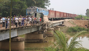 Ảnh: Ôtô bị tàu hoả đâm biến dạng chênh vênh trên sông