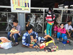 Phụ nữ, trẻ em vạ vật dưới trời nắng chờ xe về nghỉ lễ