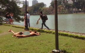 Hai du khách Tây ăn mặc phản cảm, nằm trên bãi cỏ ở Hồ Gươm