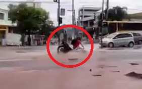 Xe máy lọt hố, bị 'nuốt chửng' khi băng qua đường ngập