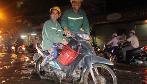 TP.HCM: Chồng còng lưng đẩy vợ vượt triều cường