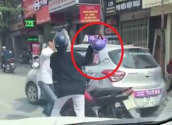 Va chạm giao thông, phụ nữ cầm mũ bảo hiểm 'phang' tài xế taxi