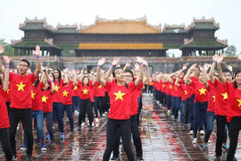 Hàng nghìn sinh viên Đại học Huế mặc áo cờ đỏ sao vàng nhảy dân vũ dưới mưa