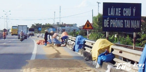 Dân 'chiếm' quốc lộ làm sân phơi thóc, xe máy bị đẩy ra 'làm mồi' cho xe tải