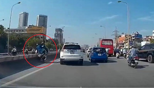 Ô tô chuyển làn đột ngột, người đi xe máy bay qua dải phân cách