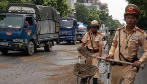 Xe máy trượt ngã do vết dầu loang trên phố, CSGT xúc cát rải đường