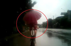 Thiếu nữ đi xe đạp điện cầm ô, đâm sầm vào đuôi ô tô