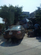 Va chạm với xe con, xe khách húc đổ mái hiên nhà dân