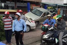 Ô tô chồm lên vỉa hè, cắm đầu vào chiếc xe đang sửa