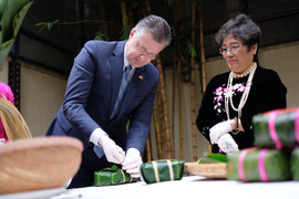 Đại sứ Mỹ Daniel Kritenbrink hào hứng học gói và cắt bánh chưng bằng lạt