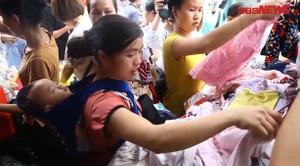 Video: Mẹ địu con ngủ gật đi nhận quần áo sau vụ cháy ở Đê La Thành