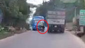 Clip: Xe máy lách qua khe hẹp giữa xe khách và xe tải như phim hành động