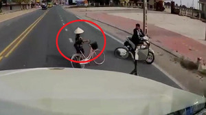 Clip: Người đi xe đạp liều chết lao sang đường, tài xế container phanh 'cháy lốp'