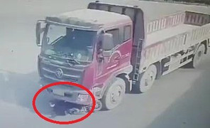 Clip: Bị xe tải kéo lê hàng chục mét, cô gái đứng dậy đi lại như thường