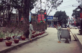 Hạnh phúc giản đơn ngày cận Tết: 2 cô lao công tạo dáng bên hoa đào, chụp ảnh cho nhau sau khi quét dọn đường phố sạch sẽ