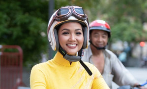 Hoa hậu H’Hen Niê mặc áo dài vàng, rạng rỡ chạy xe máy trên đường phố
