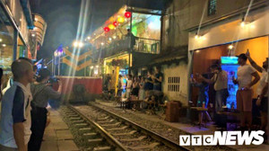 Video: Du khách liều mình uống cà phê, chụp ảnh ngay sát đường ray tàu ở Hà Nội