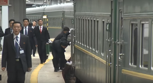 Vệ sỹ Triều Tiên hối hả chạy theo tàu, lau tay cầm và bậc cửa trước khi ông Kim xuất hiện