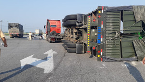 Xe đầu kéo lật nghiêng, hàng chục khúc gỗ lớn tràn ra đường