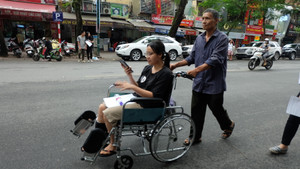 Cha đưa con gái ngồi xe lăn đến trường làm thủ tục thi THPT Quốc gia 2019