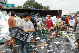 Xe chở trái cây bị lật, cảnh sát cùng người dân dầm mưa gom hàng giúp tài xế