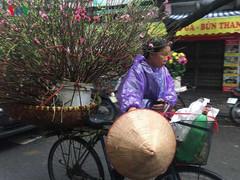 Ảnh: Nhọc nhằn mưu sinh trong mưa phùn gió bấc trên đường phố Thủ đô