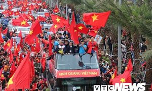 Cầu thủ U23 Việt Nam đứng trên xe buýt mui trần vẫy tay chào người hâm mộ Thủ đô