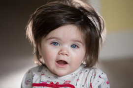 Bé gái 7 tháng tuổi có mái tóc dài, bồng bềnh đen nhánh