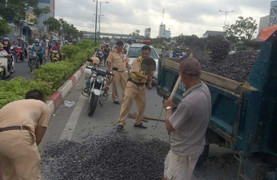 Bốn chiến sỹ CSGT đội nắng, thuê xe hốt đá dăm vương vãi trên đường