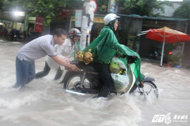 TP.HCM: Nhiều người vật lộn giúp người đi đường vượt qua 'dòng thác' giữa phố